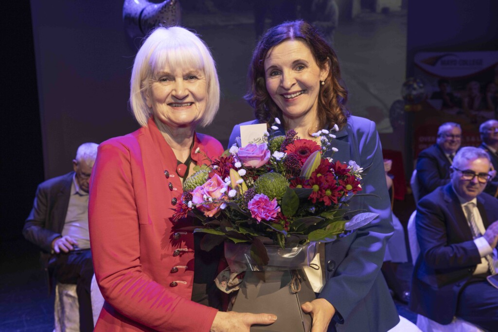 Minister Harkin presenting flowers to Mary Madden, Director of Schools, on behalf of Mayo College in recognition of her dedicated service as she retires.