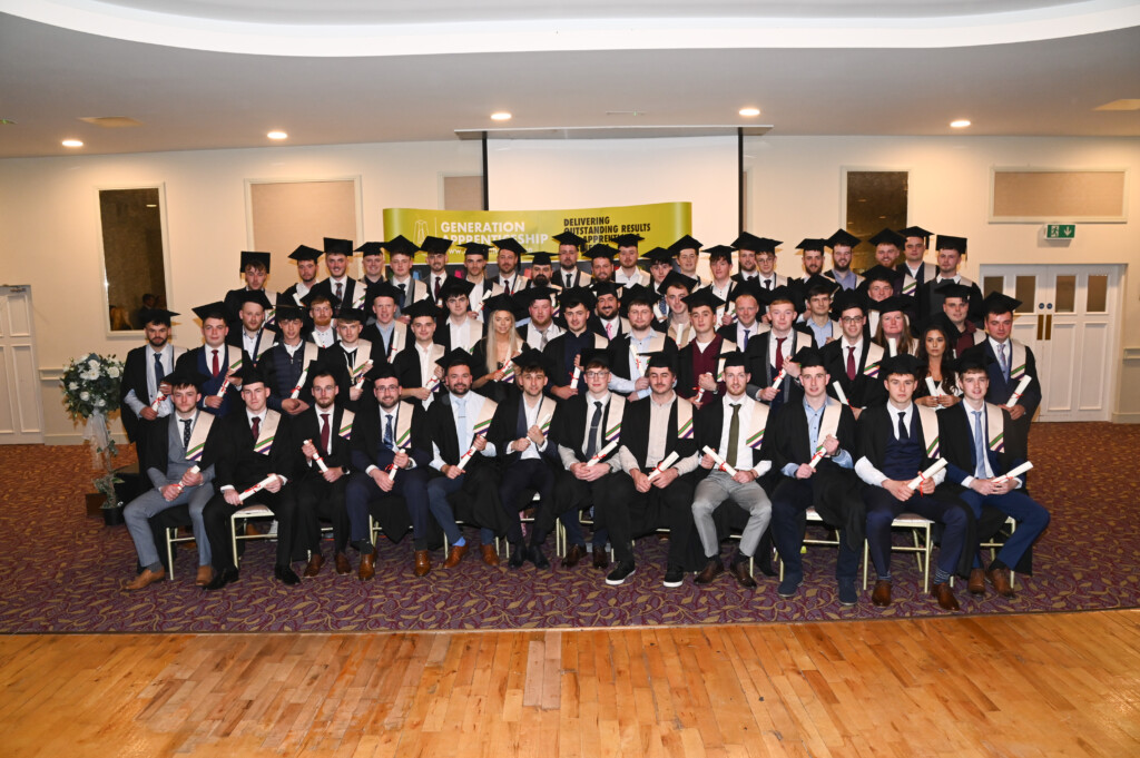 Group of people in graduation caps and gowns holding their scrolls.